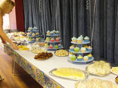 Long party buffet table with platters and a cupcake stand