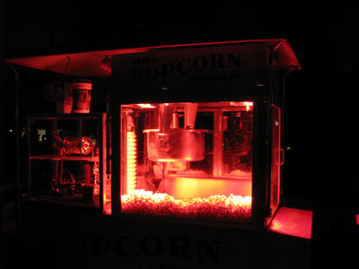 A popcorn machine glowing at night with fresh popcorn inside